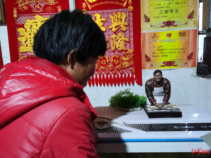 ▲“拉面嫂”和粉丝赠送的“拉面哥”小塑像