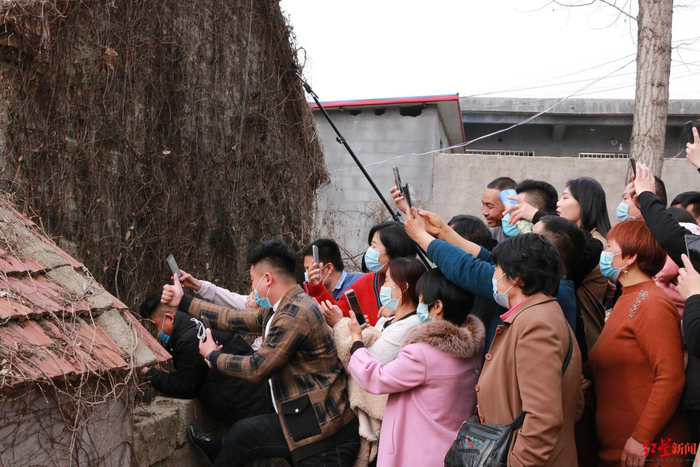 ▲在“拉面哥”家院外向内围观及直播的人群
