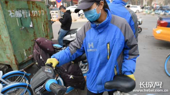 池晓敏正在整理路边的助力车