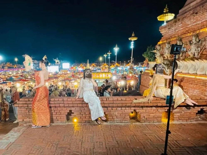 在摄影师指点下熟练摆出pose的傣妹们