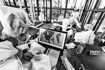 此次四川省广汉市三星堆遗址考古发掘和保护研究充分运用现代科技手段，实现考古发掘、科技考古与文物保护全过程紧密结合。图为考古人员在发掘现场利用电脑查看新发现的象牙雕，并进行记录。