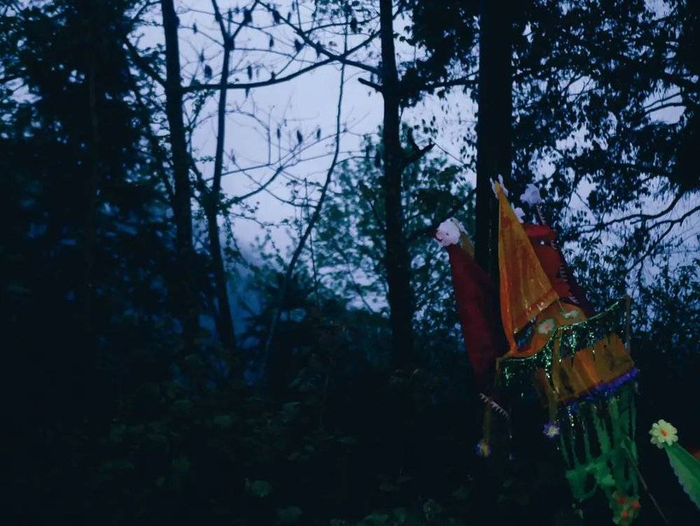 我到这里时快傍晚了，天下着雨，看到这些绚丽的祭祀物品，感到有些沉重。