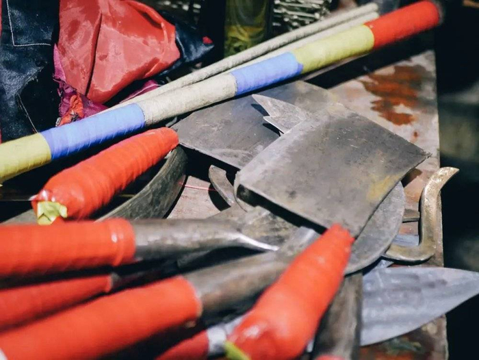 葬礼上表演用到的刀，表演结束后，围观的人都凑上前摸了摸，试探刀子是否锋利。