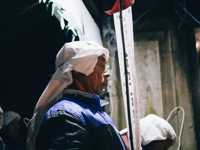 孝子拿着牌位站在最前面。