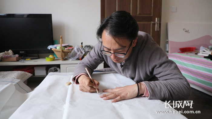 京绣的花纹以写实的工笔绘画为稿本，图为陈芳刚在进行绘画工序。长城网记者张登峰 摄