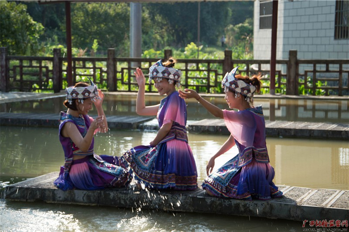 　　春日正暖，仫佬三妹笑靥如花地在池边嬉戏玩耍，头上戴着的银铃“叮当叮当”清脆地响，嘴中吟唱着仫佬族经典山歌，喜迎“壮族三月三”节日的到来。（南宁轨道交通集团有限责任公司纪委供图　银婷婷/摄）