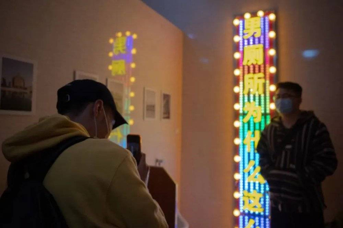 男观众在灯牌前留影