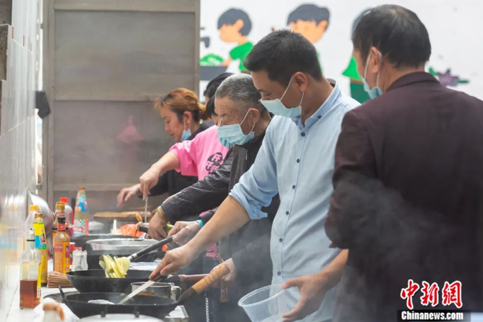 切菜、炒菜、煲汤……临近中午，江西省肿瘤医院旁的一条小巷内十几个炉灶一字排开，来往的病人家属在此忙碌不停，不时有饭菜香味飘出，烟火气十足。 刘力鑫 摄