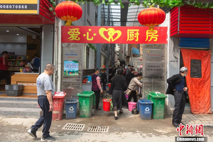 正午时分，不少病人家属提着一个小桶走进厨房，桶里装着餐具、食材等，找到一个灶台撸起袖子就开始做饭。 刘力鑫 摄