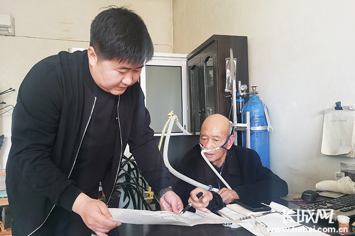 李会明（右）同现任支部书记讲解村庄规划事宜。