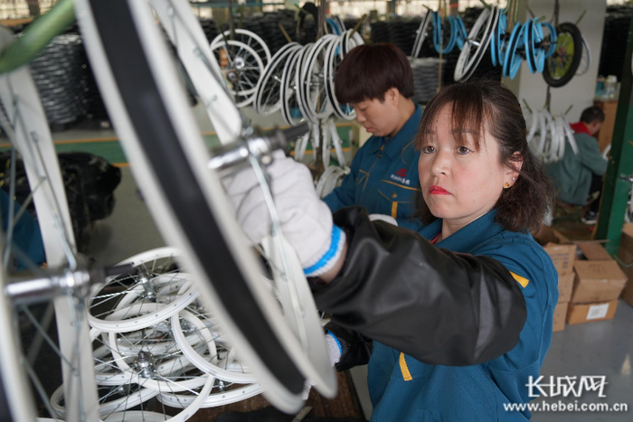 工人正在悬挂自行车轮毂。 长城网记者 胥文燕 摄