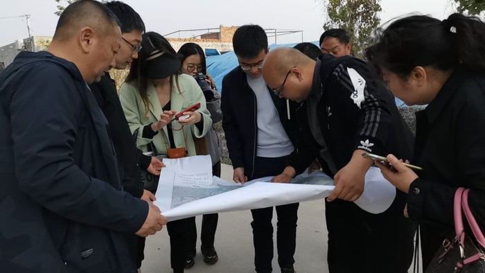 新华社记者与当地干部一起查看吕村土地规划图。（新华社记者 林红梅 摄）