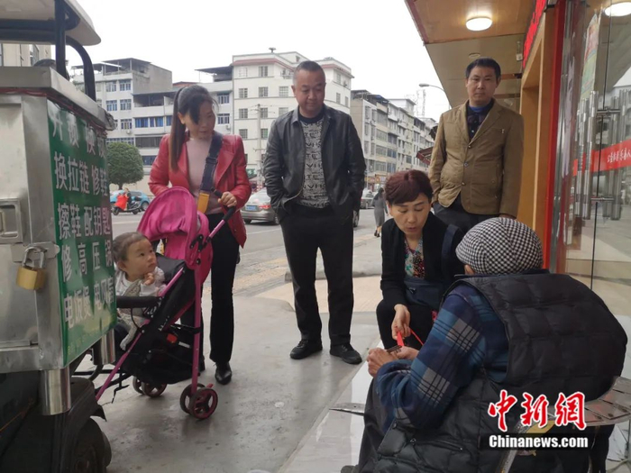 小小的摊位前总是围满了顾客。杨勇 摄