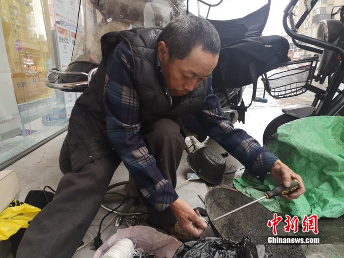 白朝平正在补锅。杨勇 摄