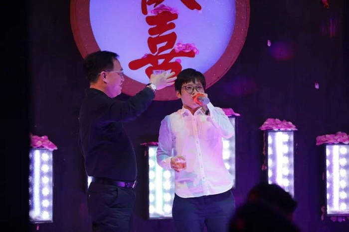 客人在台上演唱，一同来的邻居大哥上去给她敬酒