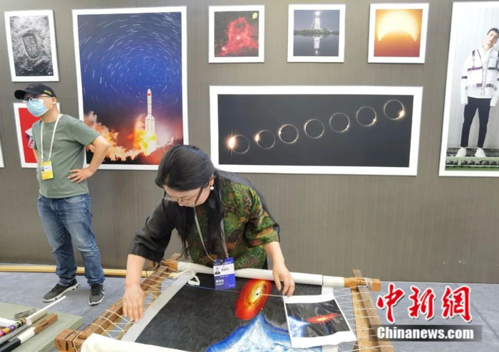 苏州绣娘陈英华在中国航天日，科普巡展上展示创作过程。朱晓颖 摄