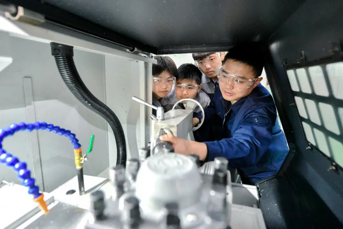 浙江省长兴职教中心的开放式实训中心内，数控专业的学生正在教师的指导下赶制楔形块产品。（谭云俸 摄/ 视觉中国供图）