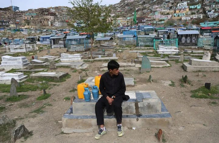 4月16日，一名男孩在阿富汗喀布尔一处墓地卖水。美国总统拜登宣布，美军将于5月1日开始从阿富汗有序撤离，美军以及北约驻阿军队将于9月11日前撤出。新华社发（拉赫马图拉·阿里扎达摄）