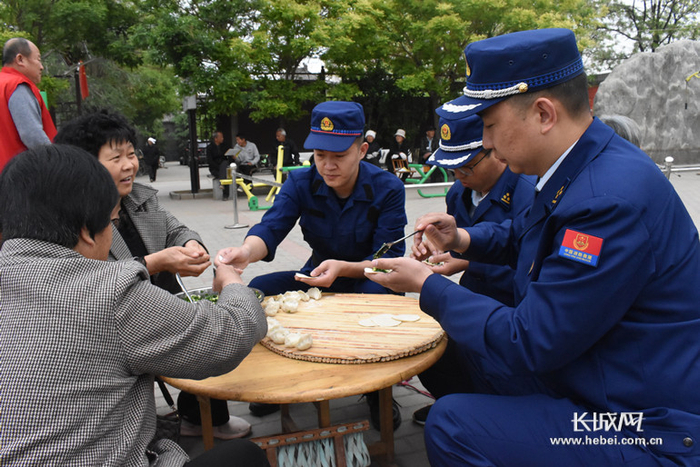 消防指战员与村民一起包饺子。图片由通讯员提供。