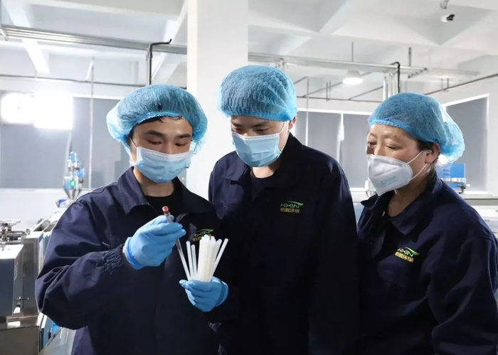 恒鑫环保科技有限公司生产人员用口径规测量吸管内径，确保产品标准满足客户需求。王春燕摄