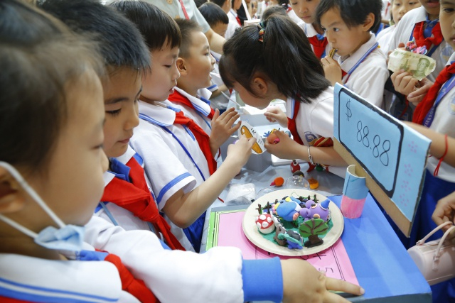 海景学校学生在校园里搭建义卖平台，销售超轻黏土作品。 刘晓惠 摄