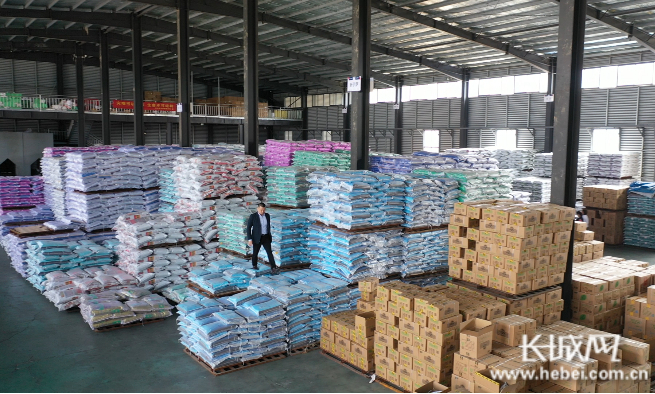 马少进在邢台市伊萨宠物食品有限公司仓库内查看货物。 记者 郭硕 摄