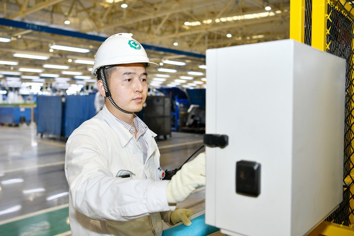 洪威（左一）与同事交流设备保全事项 记者 吴杨/摄