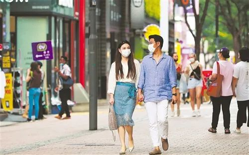 图为人们戴着口罩走在韩国首尔明洞的街道上。王婧嫱摄（新华社）