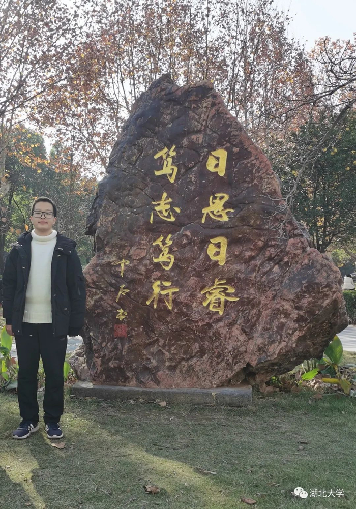 △ 罗行与校训石的合影