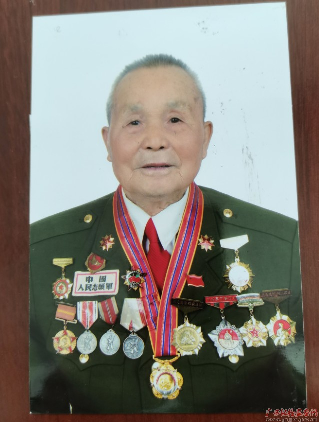 覃照群佩戴军功章照片。