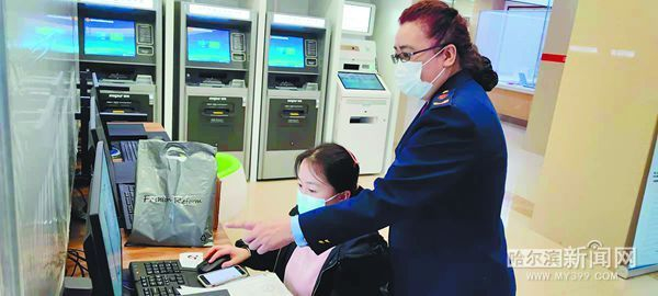 张静萍（右）在市民大厦协助申请人通过网络办理注册登记业务。