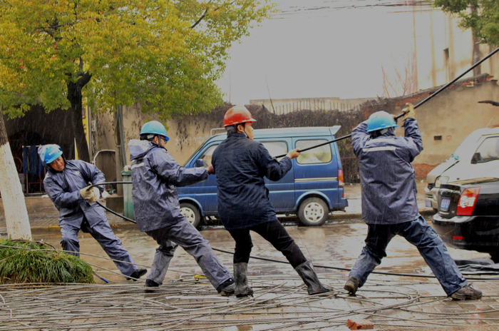 芜湖供电公司供电所人员正在冒雨开展线路放线作业，抢修受损线路（鲁云琛）