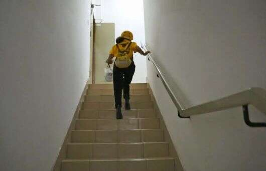 为赶时间而选择爬楼梯的女骑手