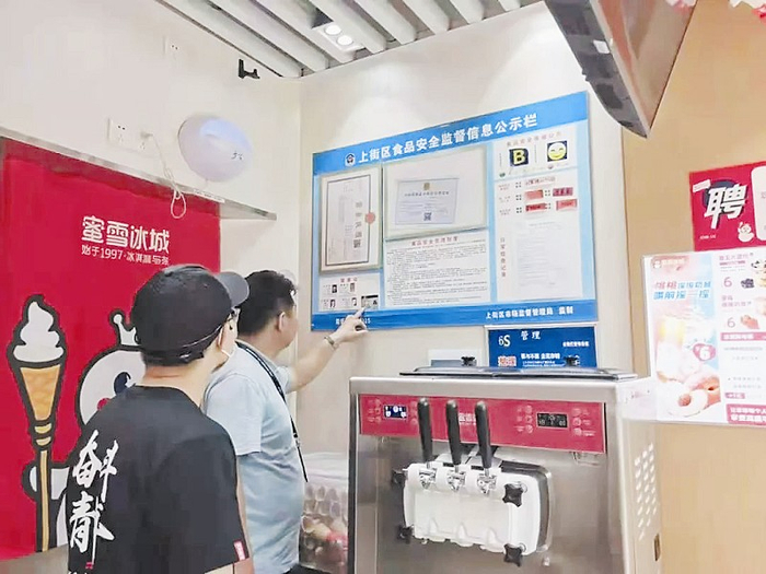 　图：郑州市市场监管部门执法人员对蜜雪冰城门店进行检查。 资料图片