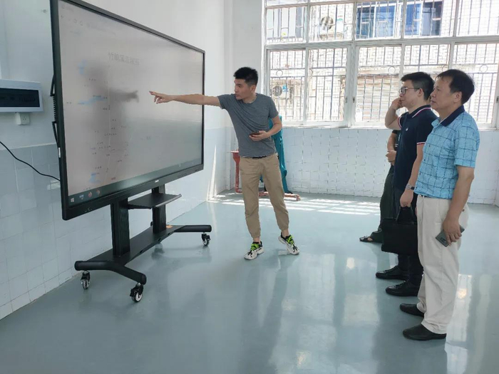 柳州市纪委监委工作人员查看竹鹅溪河道的实时水文数据，督促泵站落实防汛备汛责任。