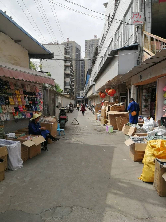 向南望，却是条杂乱小巷，两边居民楼和摊店夹峙，铁轨脉络依稀可辨。