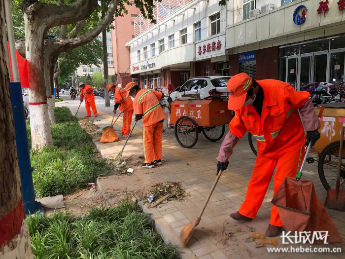 环卫工人精细化清理绿化带垃圾。 通讯员 刘张焱 供图