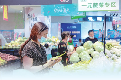 　　贵阳合力惠民生鲜超市花果园S区店，市民正在挑选蔬菜。