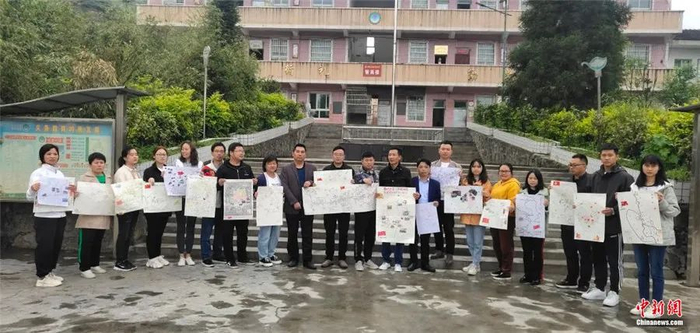 图为黄莲乡希望学校教师拿着手绘地图合影。桐梓县融媒体中心供图