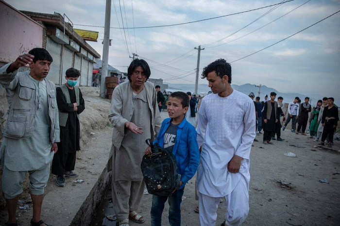 ↑在爆炸现场，一名男孩拿着或已遇难的姐姐的书包。图据《纽约时报》