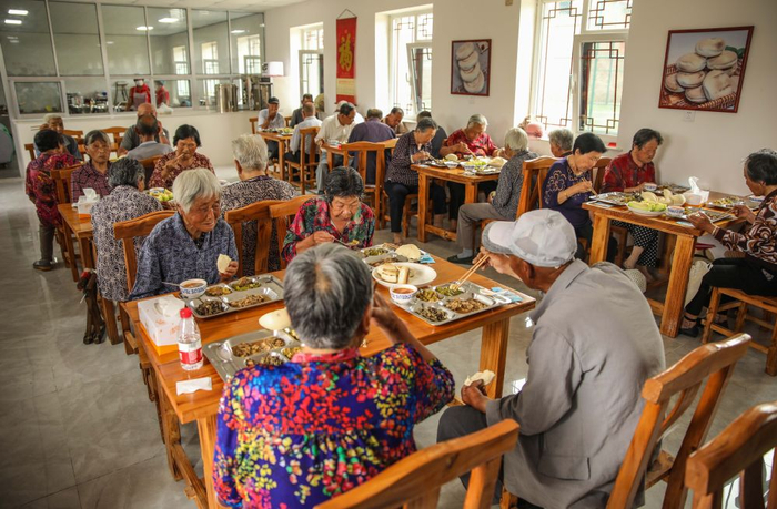为破解居家养老吃饭难，山东省荣成市全面推进“暖心食堂”建设。这是2020年7月4日，老人们在荣成石岛管理区斥山街道盛家村“暖心食堂”内用餐。