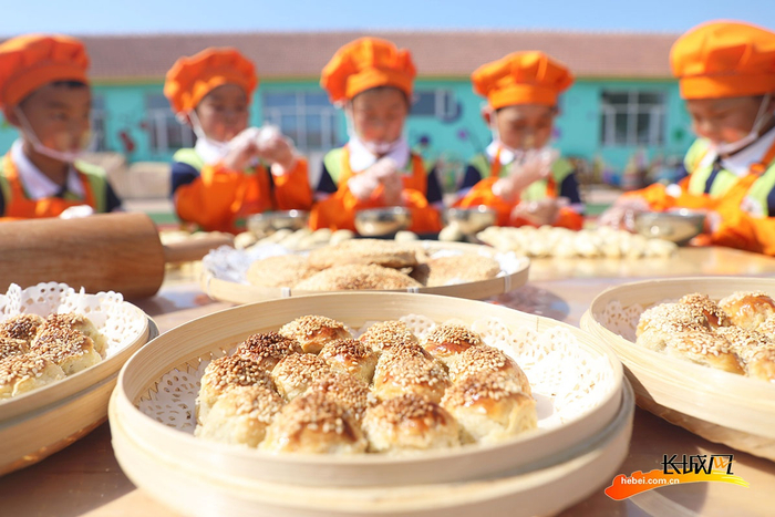 在唐山市丰润区白官屯镇燕子河幼儿园“非遗大集”上，小朋友们在制作烧饼。朱大勇 摄