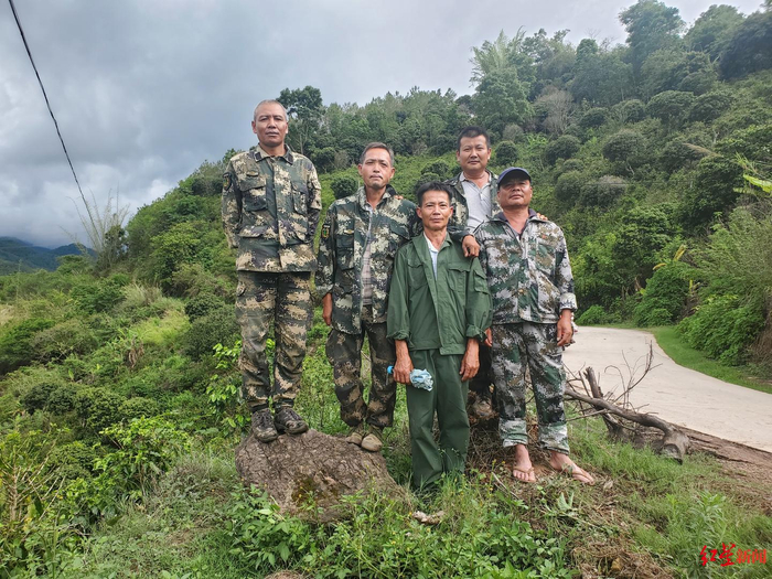  ↑6月11日，把边乡的五位大象监测员。两头返回公象就在他们身后的山上。图据红星新闻