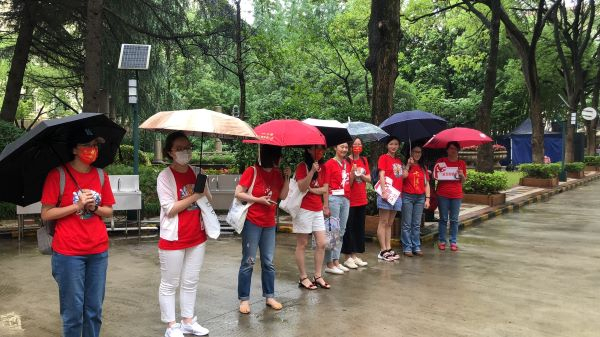 图说：延安初的送考老师用伞搭起“遮雨廊”
