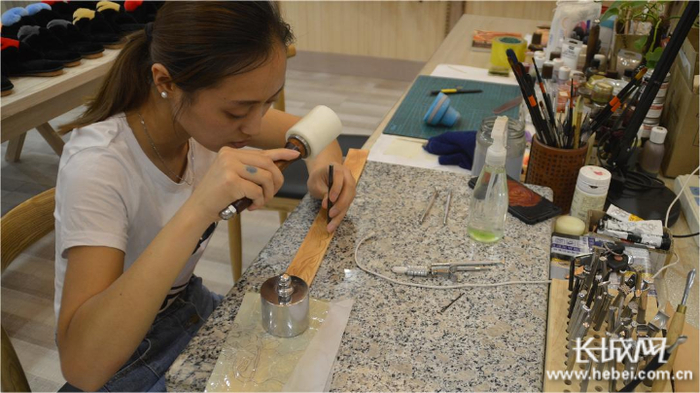 在皮雕体验区，游客可以亲手体验传统皮雕技艺，并且定制手工文创产品。长城网记者 胥文燕 摄