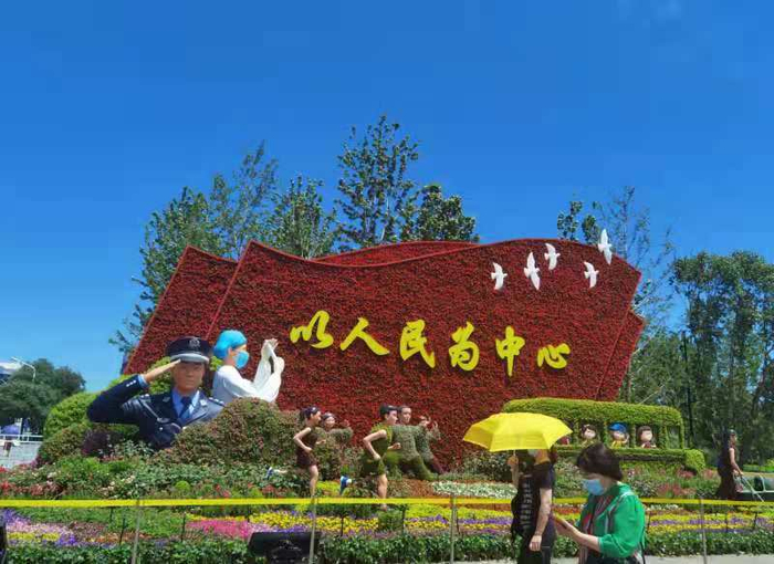 北京市长安街西单路口东北角以写有“以人民为中心”的红旗为主景的花坛。黄秋霞 摄