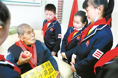 河南省信阳市第十三小学的学生们听张计发讲述上甘岭的故事。 郝光 摄（资料图片）