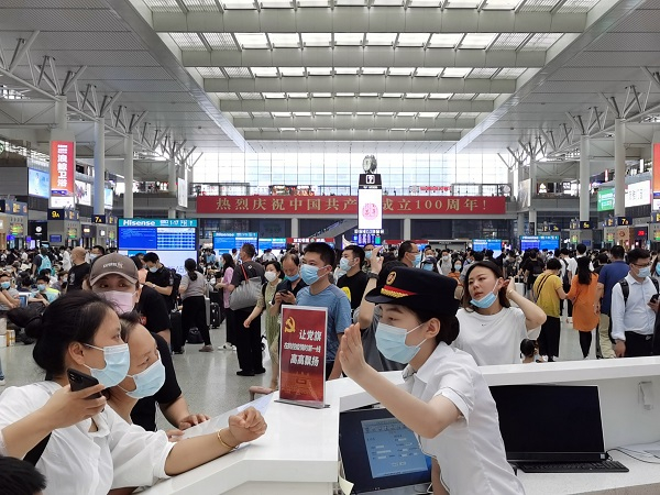 图说：上海虹桥站12306服务站工作人员为旅客提供咨询服务  王程伟 摄