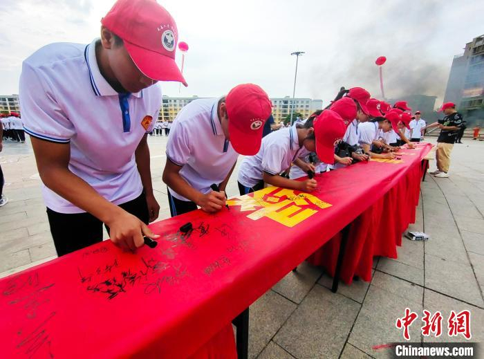 图为崇左市宁明县学生在禁毒主题横幅上签名。　黄艳梅 摄