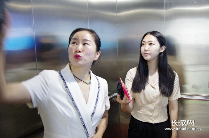 记者正在与讲解员一起进行电梯坠梯科普体验。长城网记者 刘澜澜 摄